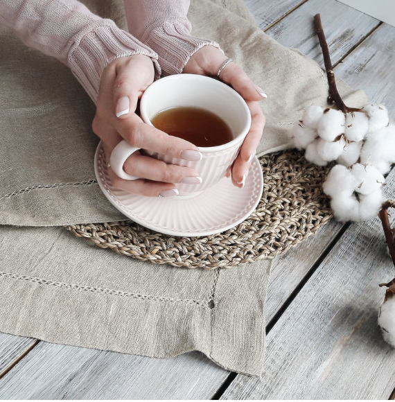 Hands holding a cup of tea.